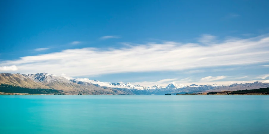 a long and turquoise lake surrounded by mountains