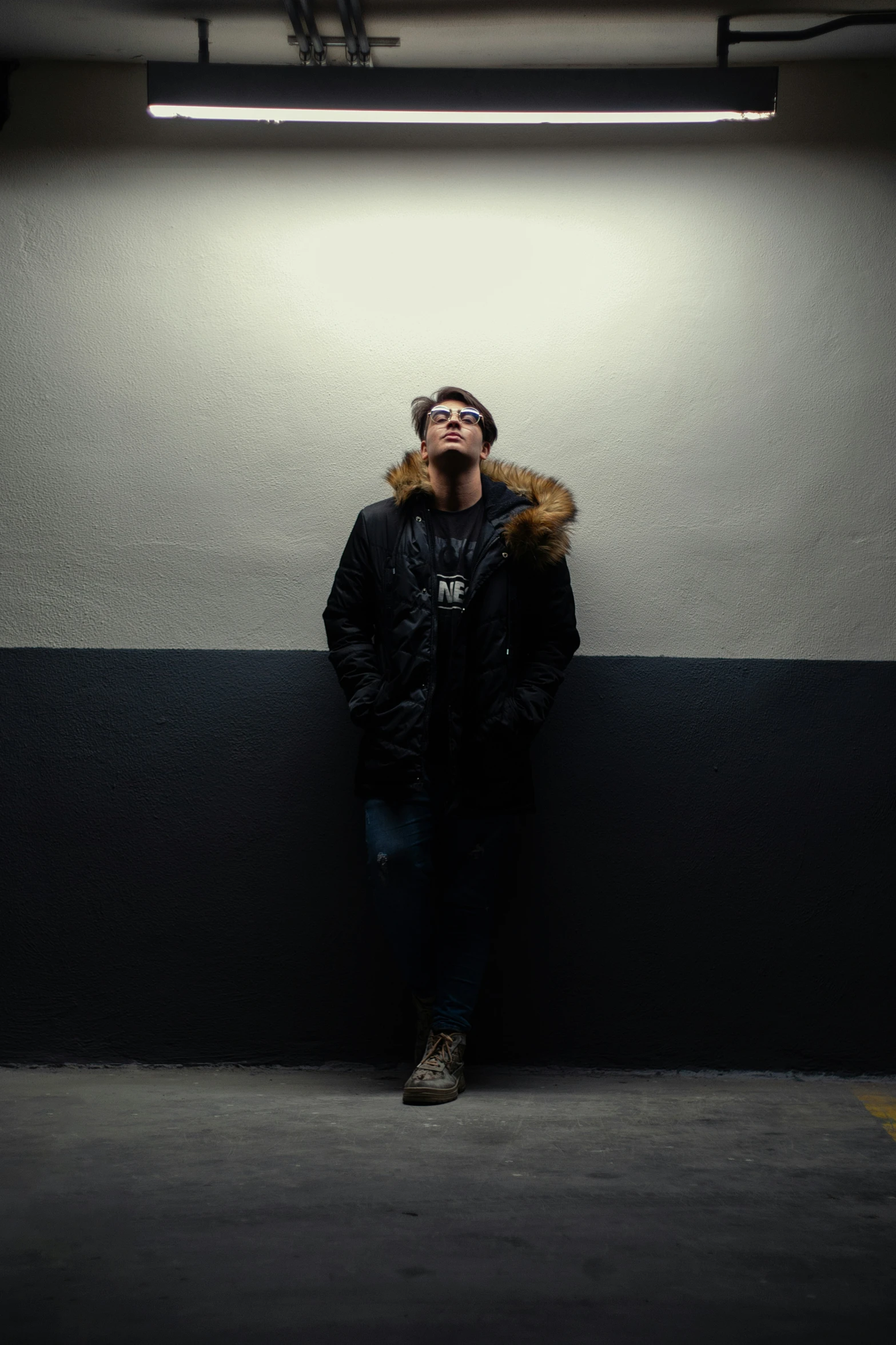 man standing by wall in a dark area with white walls