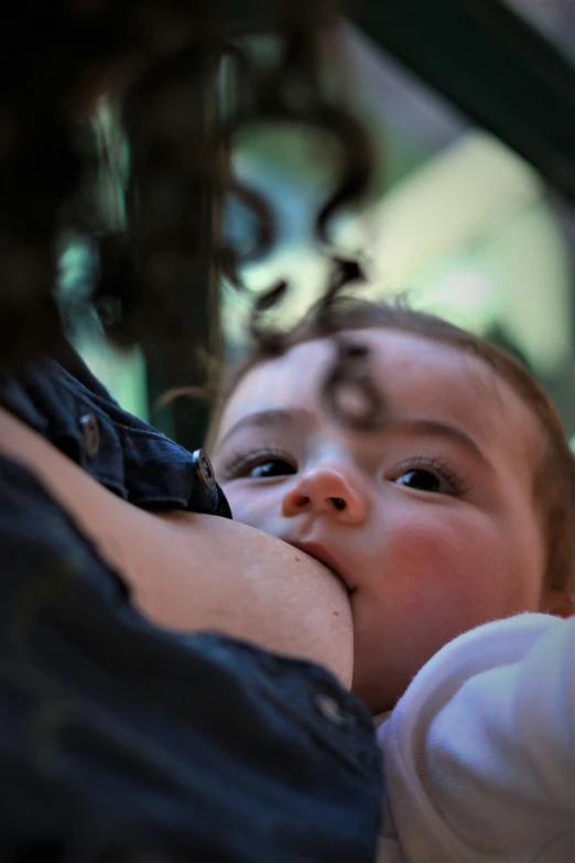 a baby holding his mother's arm in the air