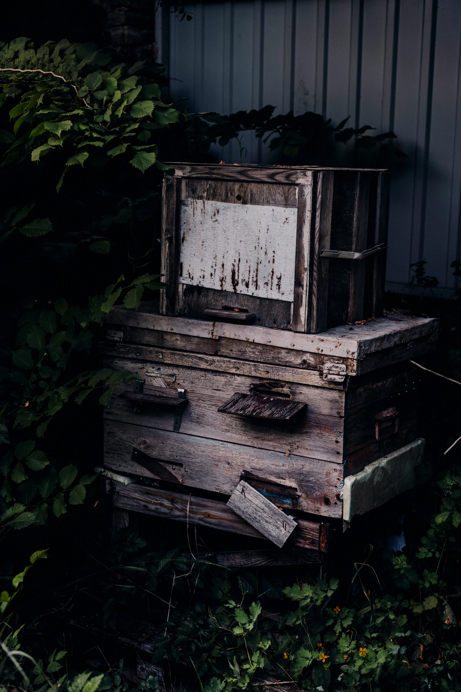 a stack of old wood with a wooden box stacked on top of it