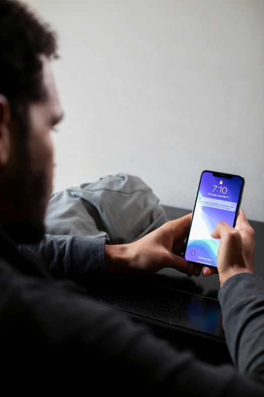 a man using his cell phone while sitting on the couch