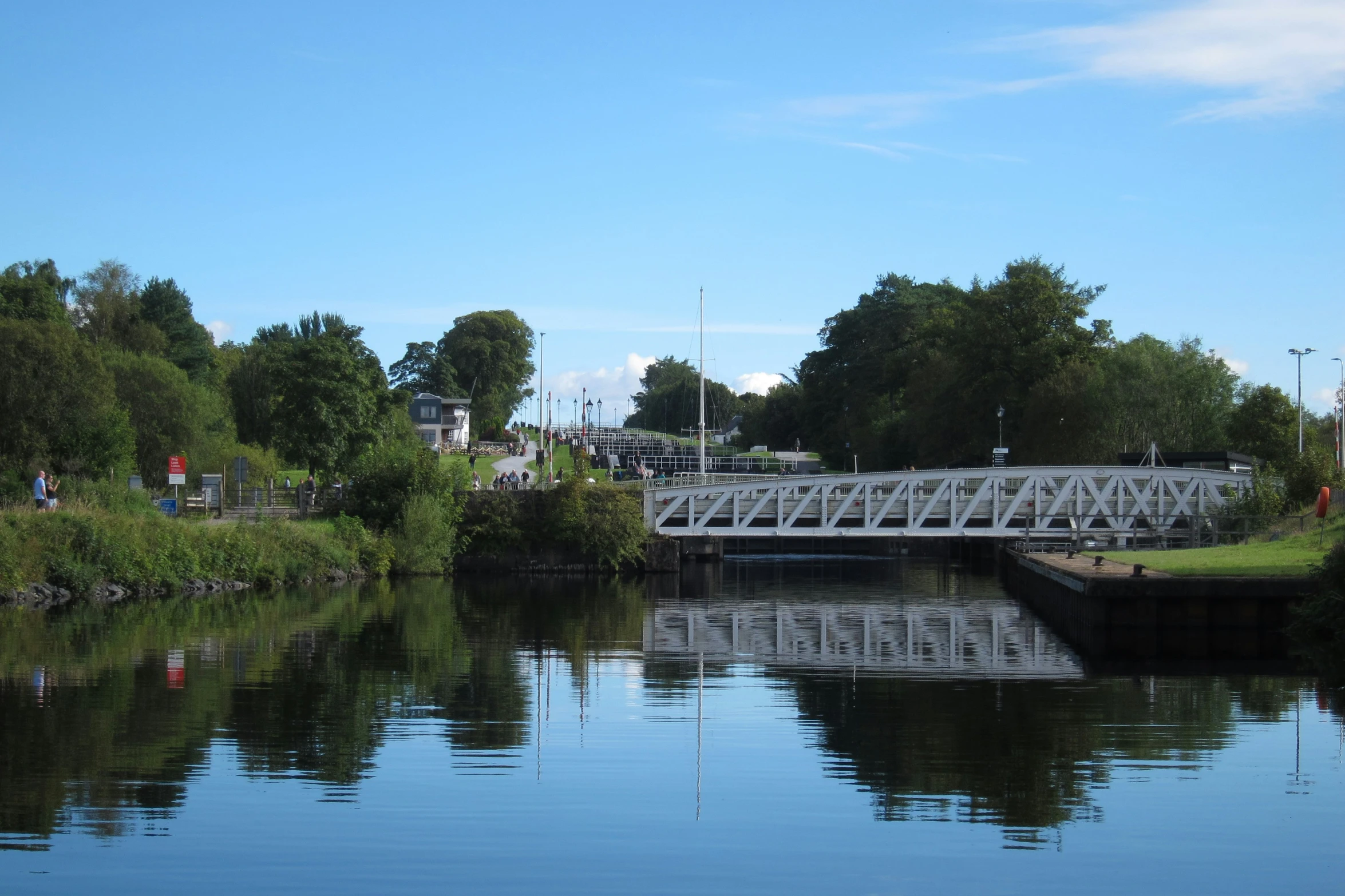 an old white bridge with a view of the water in front