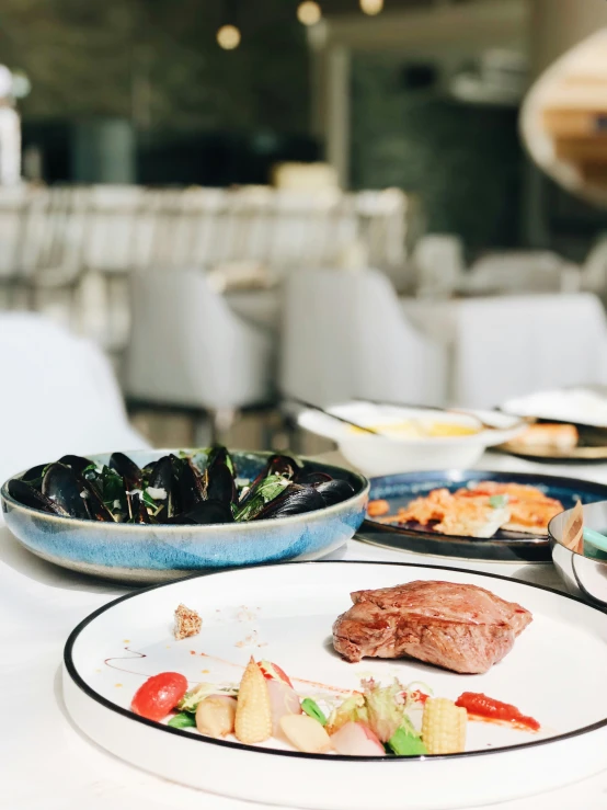 an outdoor patio has a buffet set up, including a bowl of vegetables and meat