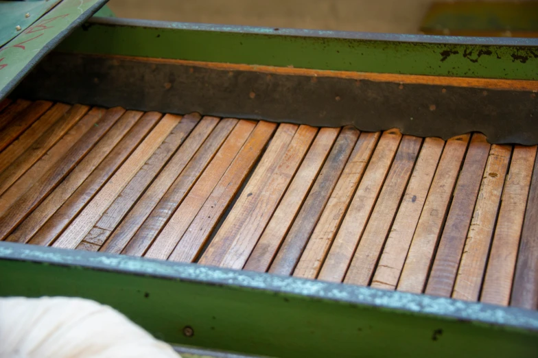 a close up of a wood bench with green paint