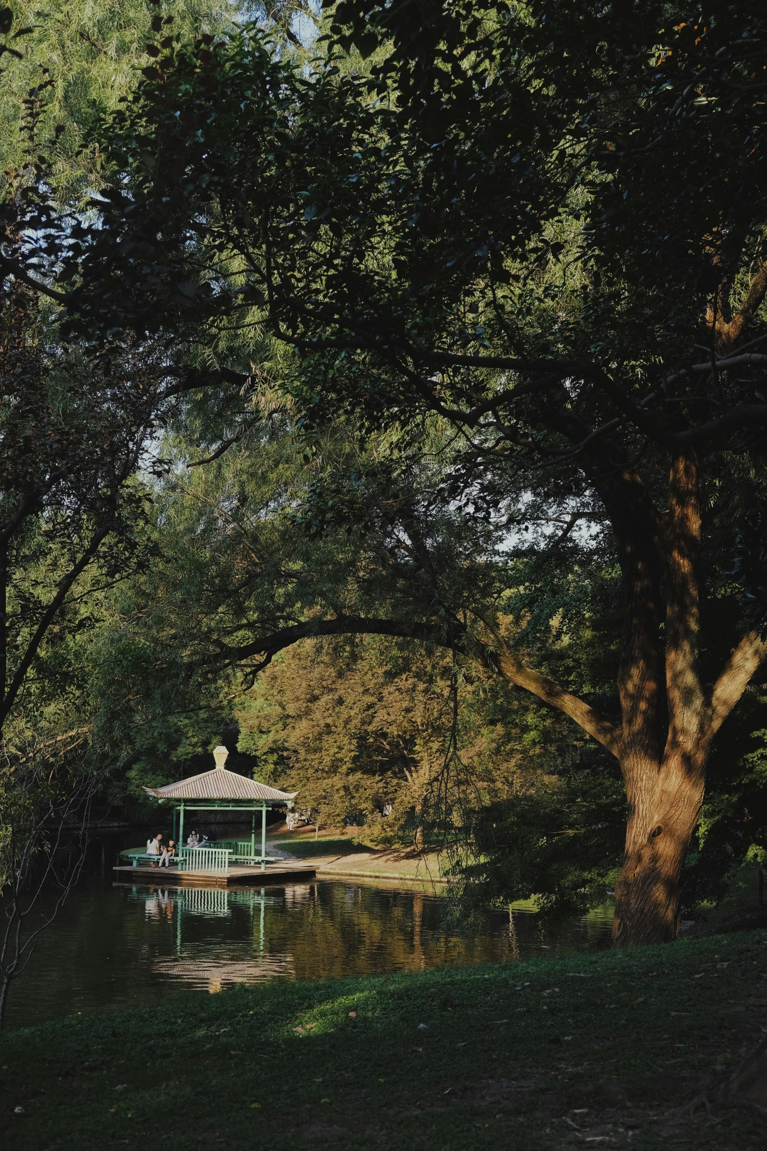 a dock with a small building and green trees near by