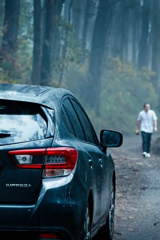 a man walking down a street next to a car