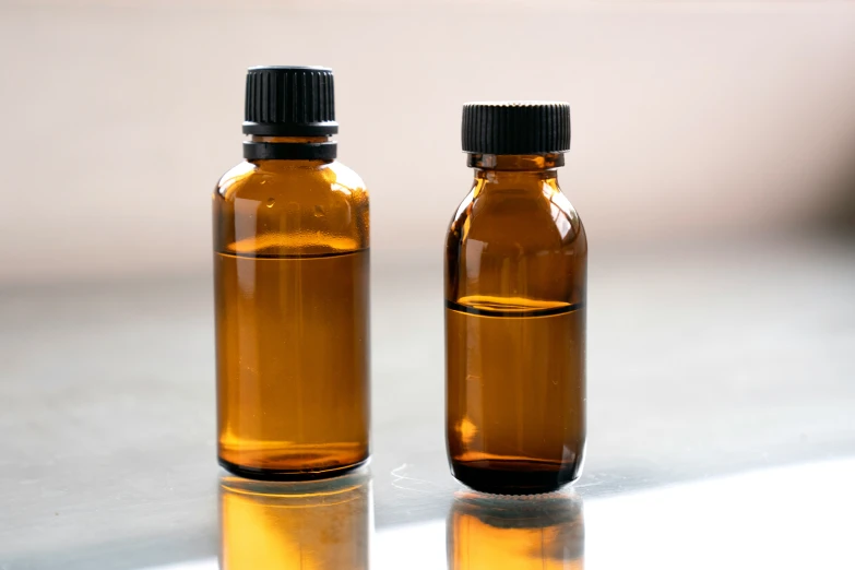 two brown bottles on a white countertop