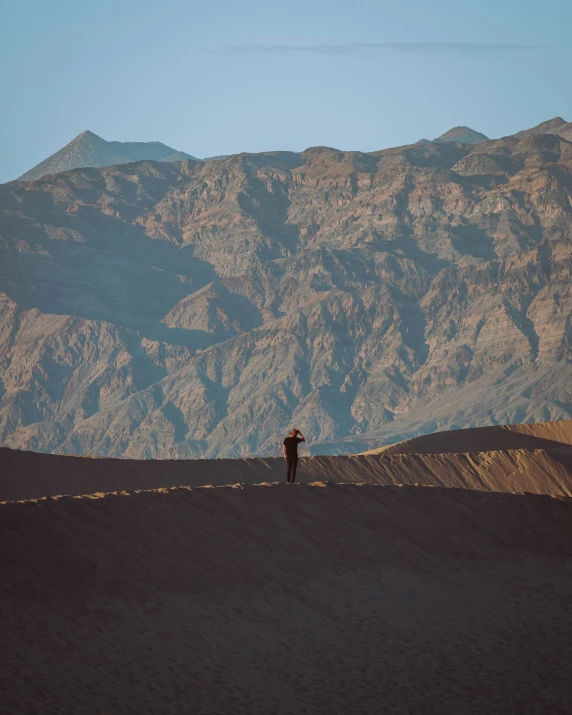 a person standing on top of a sandy hillside