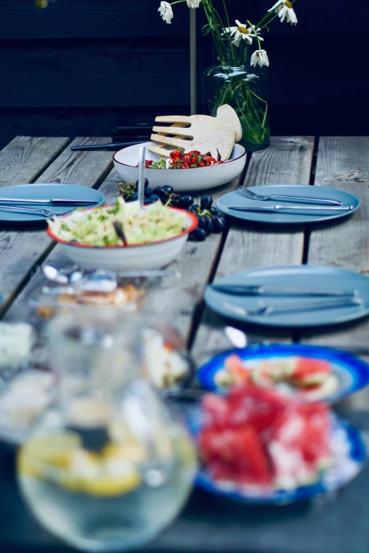 plates and knives on a wooden table near flowers