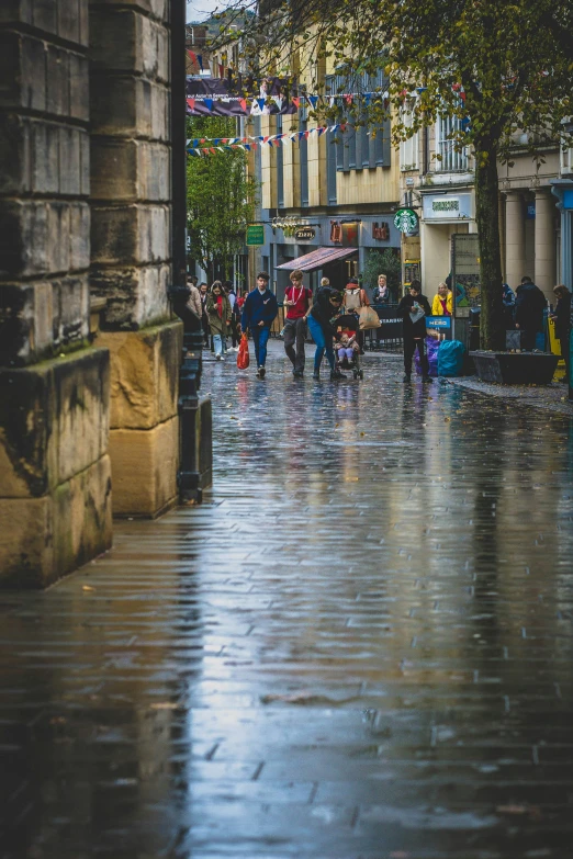 people are walking along the street in the rain