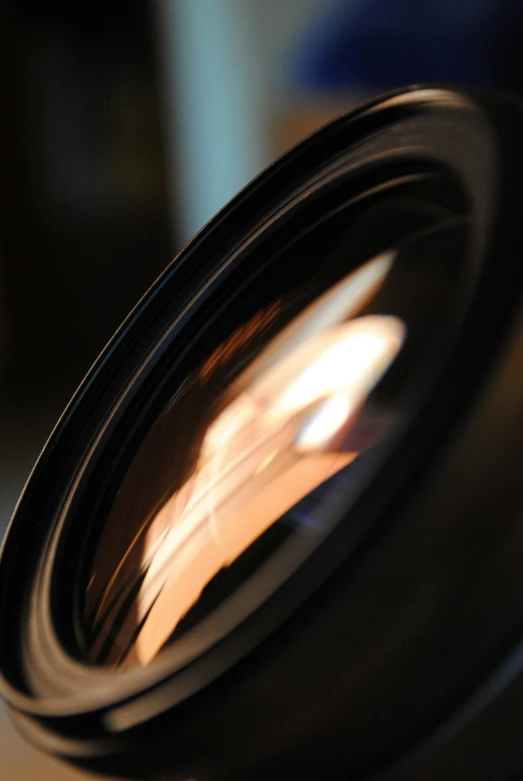 a black lens with a reflection of the camera in it