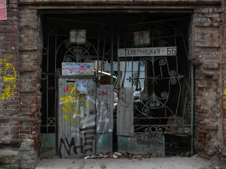 a dilapidated building with two door and graffiti on it