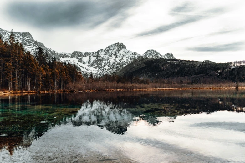 a body of water surrounded by trees and mountains