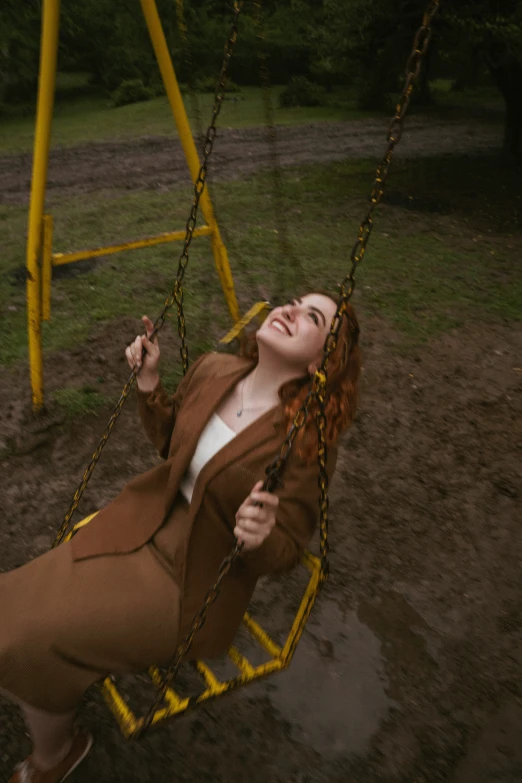 a woman laying on top of a swing next to an object