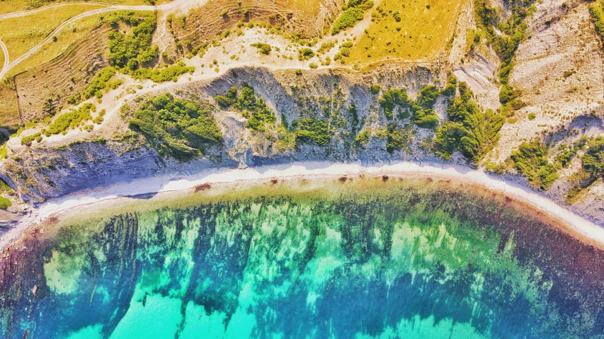 a blue and green lake with a beach in the middle