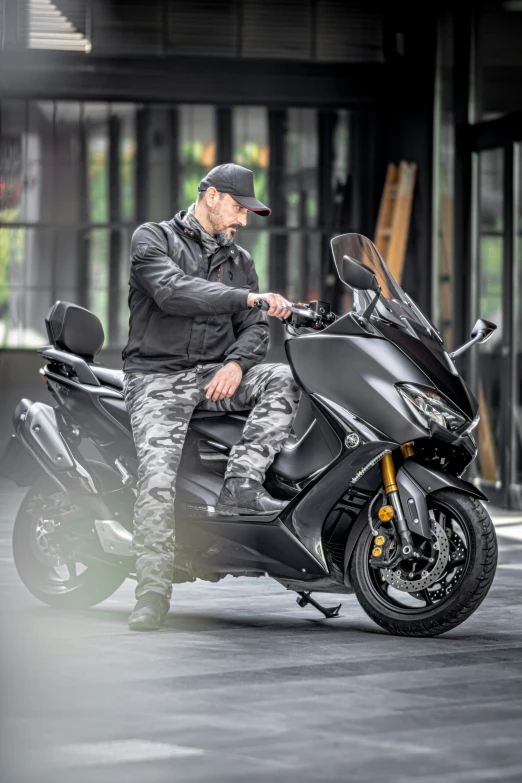 a man in camouflage gear sitting on a motor bike