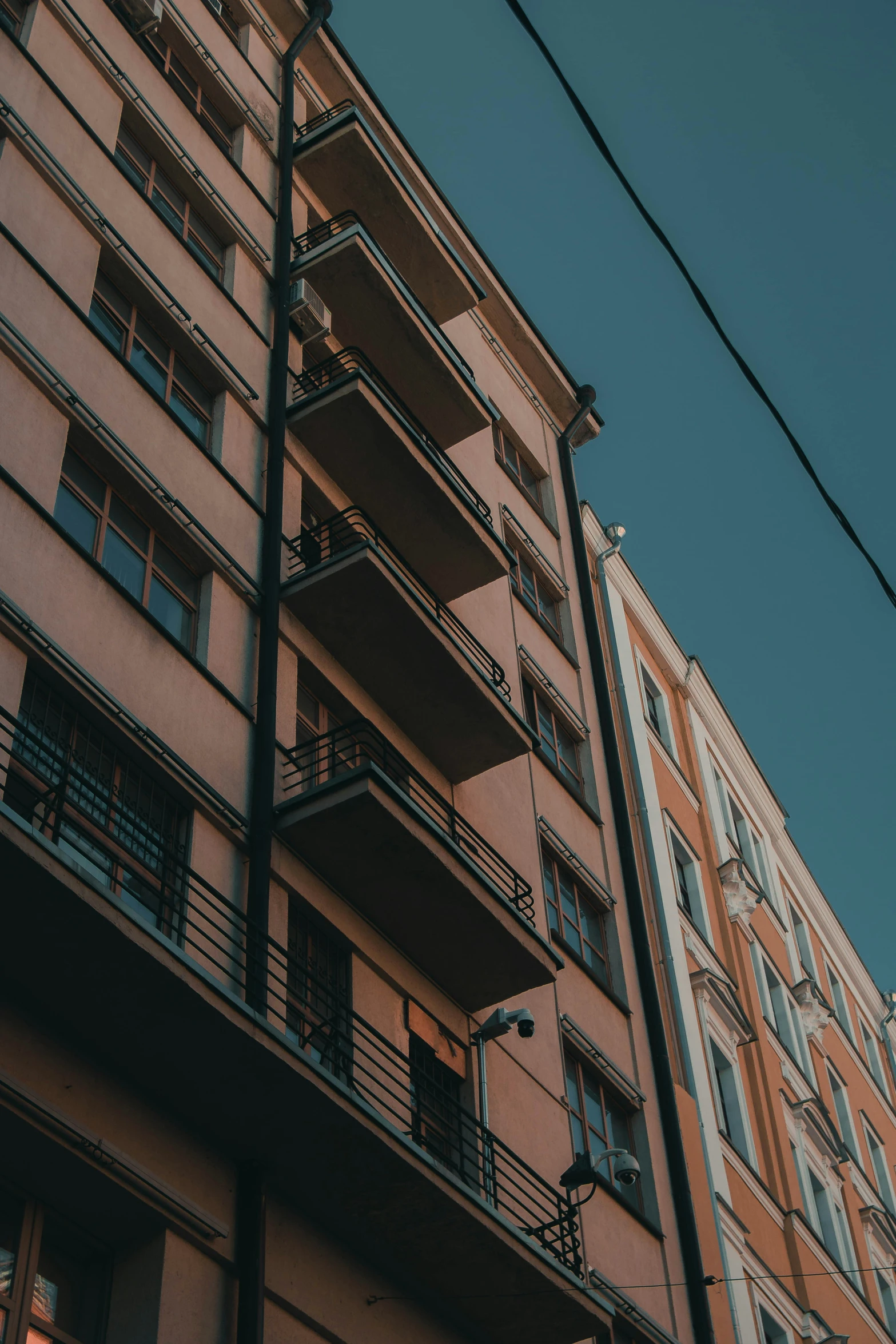 two tall buildings are shown with balconies in front