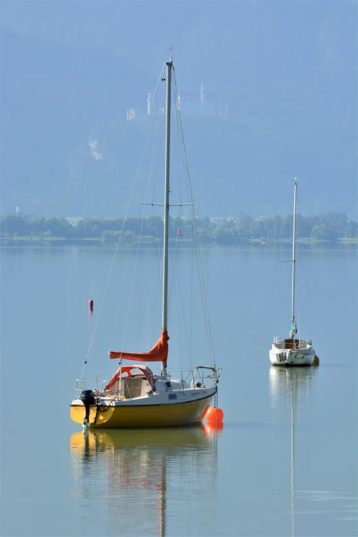 sail boats on calm lake with clear blue skies