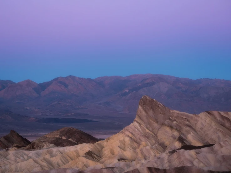 an interesting desert is shown with mountains in the background