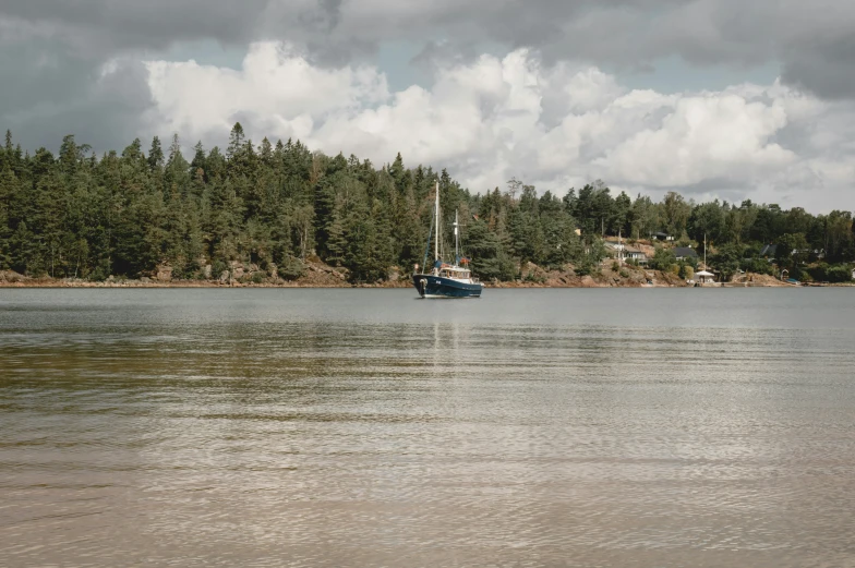 a boat sits on a small lake near trees