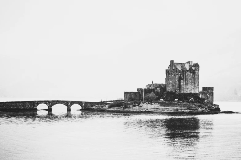 a castle that is sitting on the edge of a cliff by water