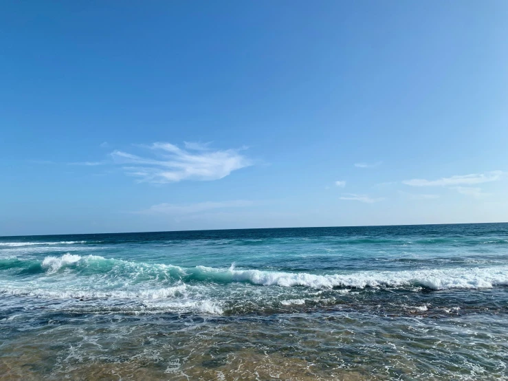 an open ocean with a small boat coming in