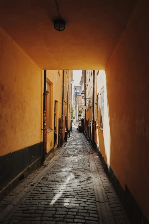 narrow alleyway between two yellow buildings in a city
