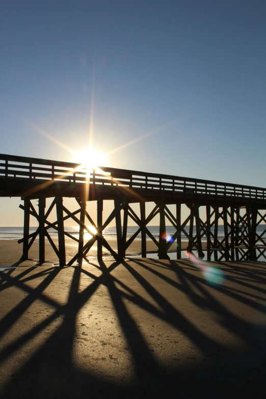 a boardwalk stretching off the sand into the sea