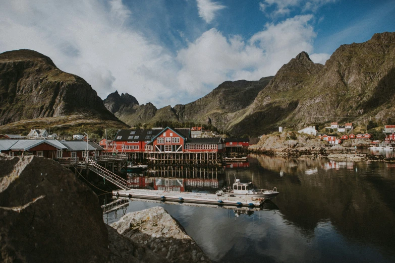 an image of a village on the water near some mountains