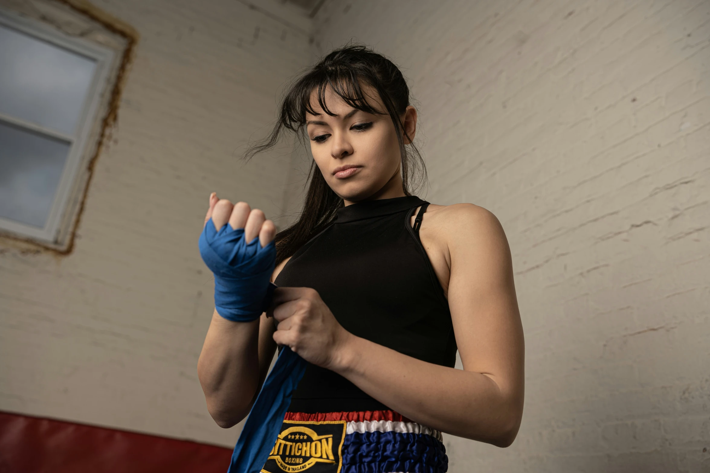 a woman wearing gloves in front of a brick wall