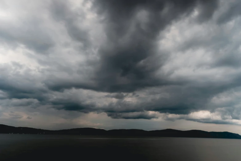 a very large cloud is over the water