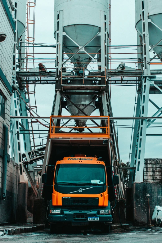 a truck parked in front of two large steel silos