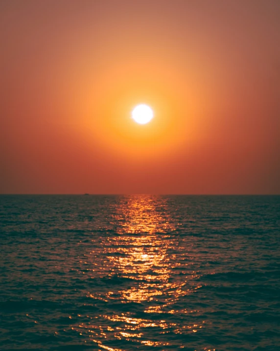 the sun setting over the ocean during sunrise