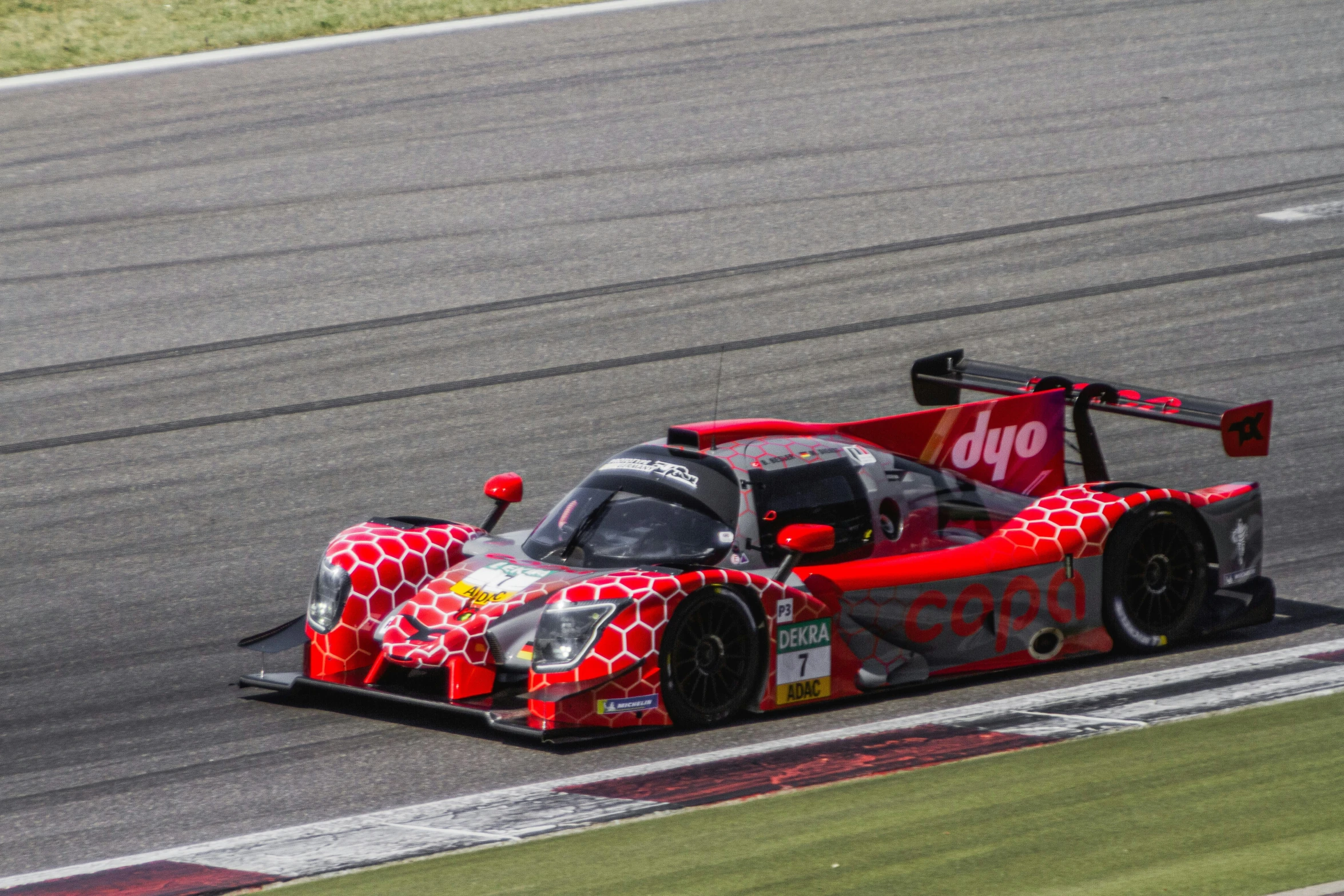 a racing car driving around the track at an auto race