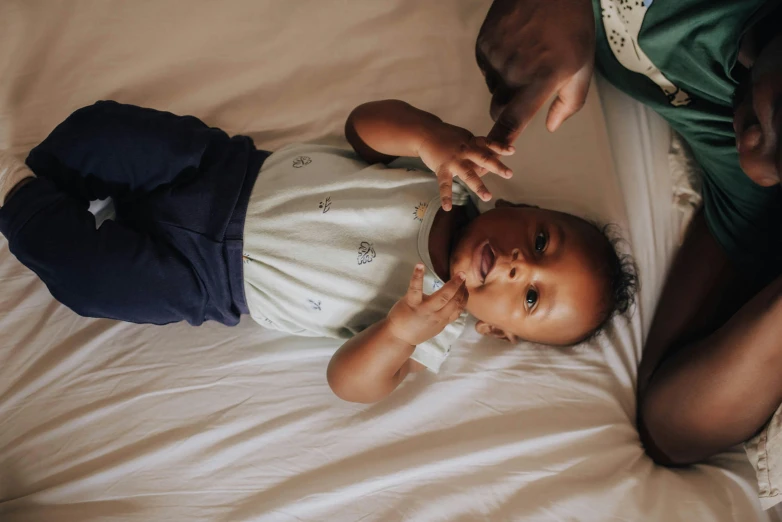 a baby on its stomach is sitting in a bed