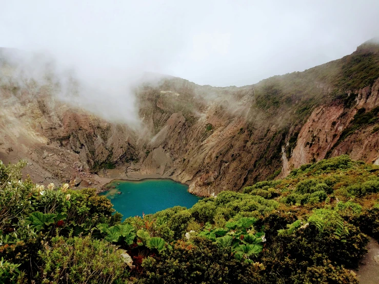 a mountain has clouds and fog covering the mountain