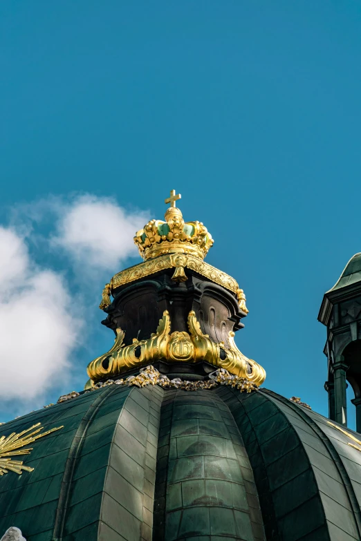 the top of an old, ornate dome with a golden crown on top