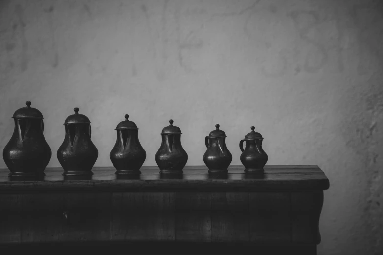 a wooden table topped with vases in black and white