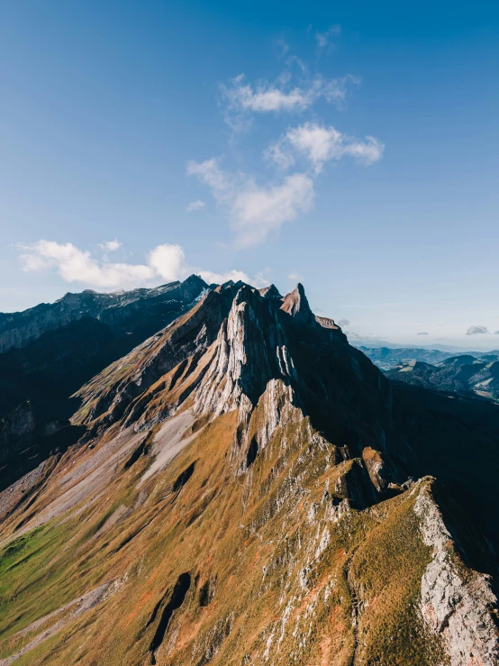 some tall mountains that have some brown grass on them