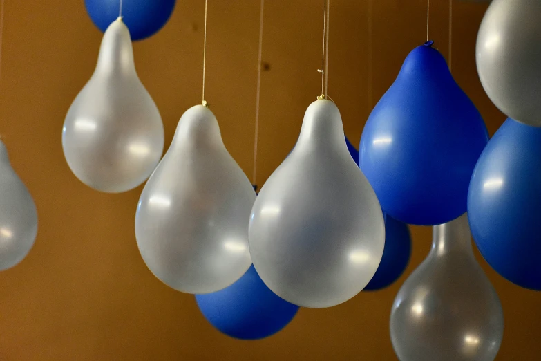 blue and white balloons hang from the ceiling