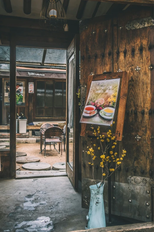 a wooden door with an easel and flowers in the front