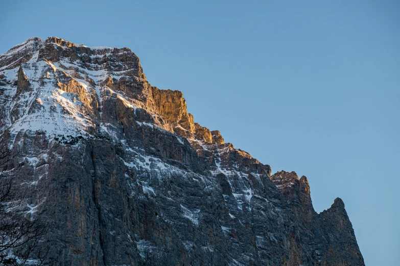 a snow covered mountain at sunset seen from the base