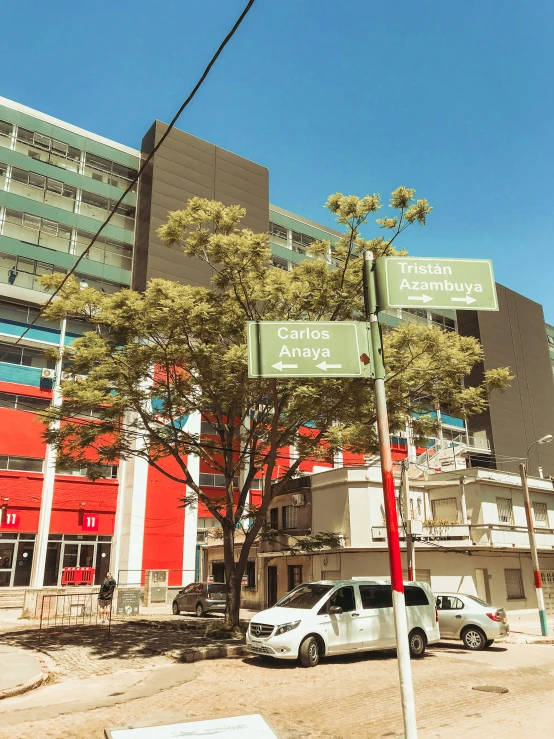 two green and white street signs on the corner