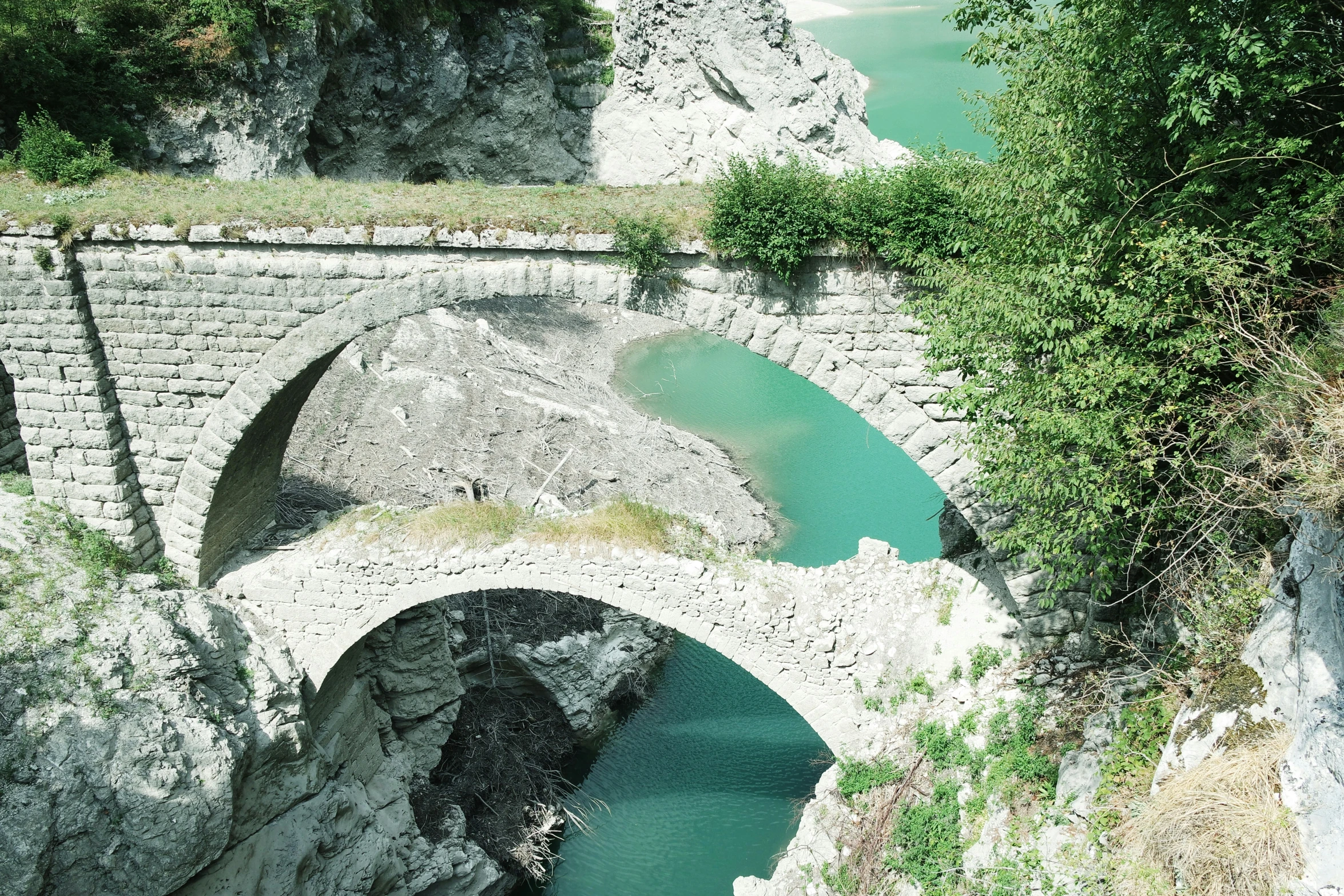 a narrow stone bridge over a body of water