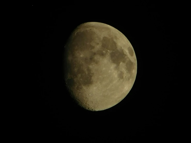 the moon shining brightly in the dark sky