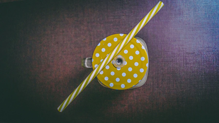 a yellow and white dot covered reel of tape next to a blue and red striped striped tape