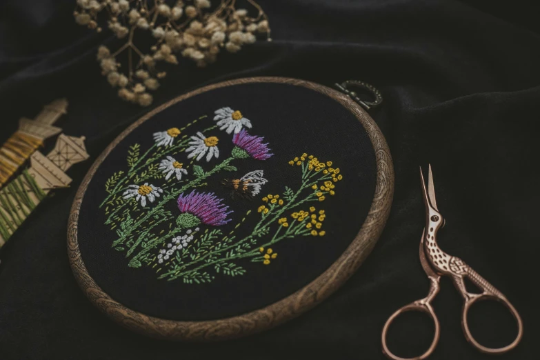 a floral embroidered piece on top of a black cloth