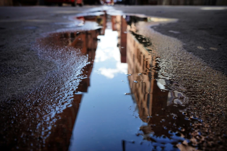 some cars are reflected in water on the street
