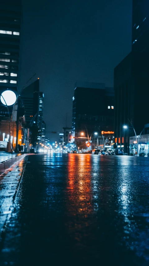 an empty road at night with a street light in the background