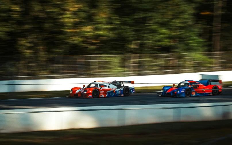 two race cars are driving on a road